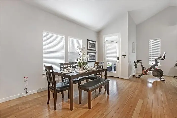 Bright dining space with rear entry and vaulted ceiling